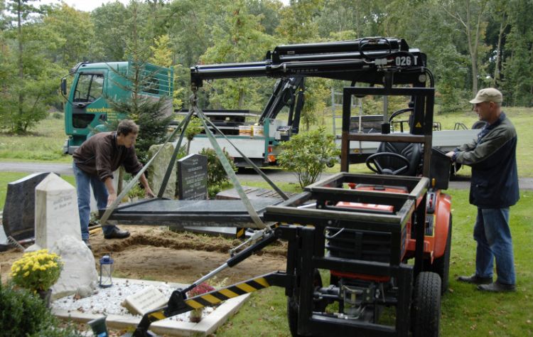 Stellen van het grafmonument op de begraafplaats met de Top-mobiel